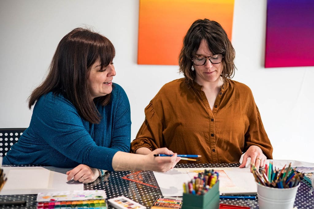 Thérèse-Marie rossi qui regarde une accompagnée et lui montre comment dessiner